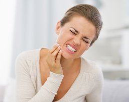 Woman with toothache holding cheek