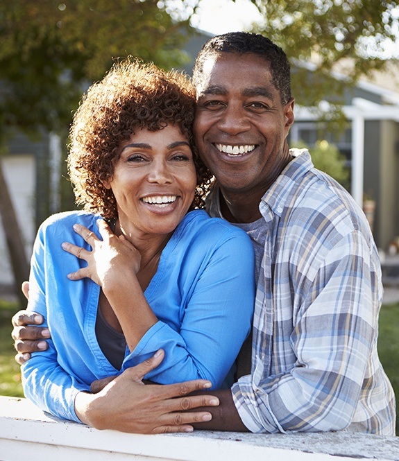 Smiling man and woman with dental insurance