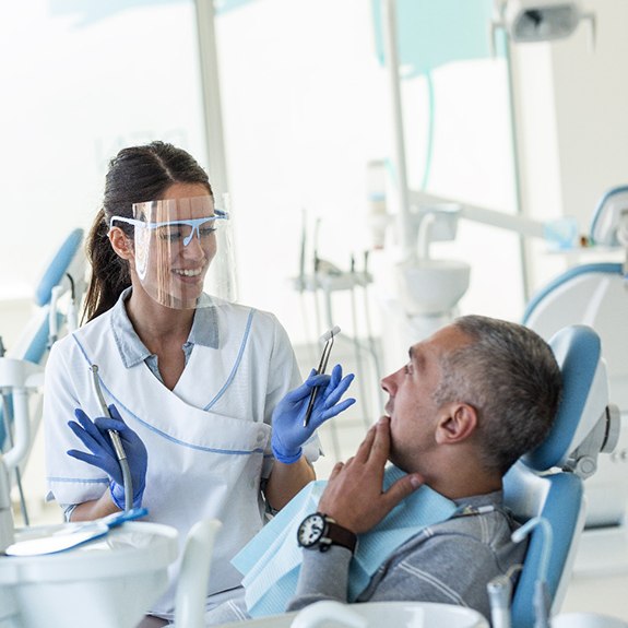 A dentist speaking with a dental patient.