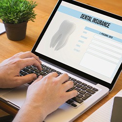 Patient filling out dental insurance form on computer