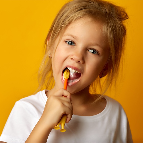 Child brushing her teeth