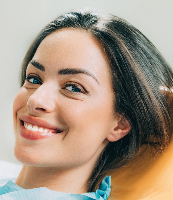 A beautiful, smiling woman sitting in a dentist’s chair
