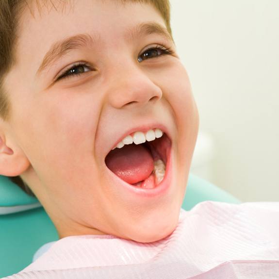 Child in Lancaster smiling in dental chair during checkup and cleaning visit