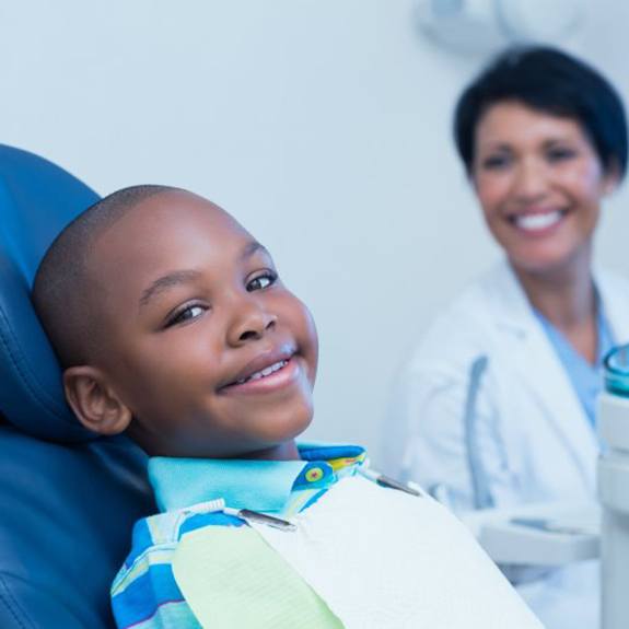 Child smiling in dental chair after dental checkup