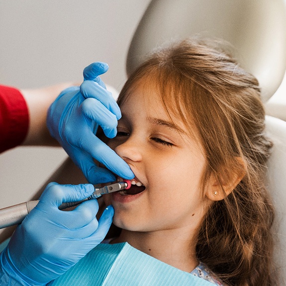 Dental hygienist cleaning a child's teeth in Lancaster