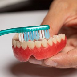 Man brushing his denture