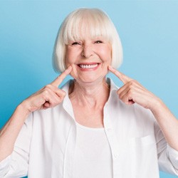 Senior woman pointing to her smile