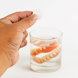 Dentures soaking in a glass