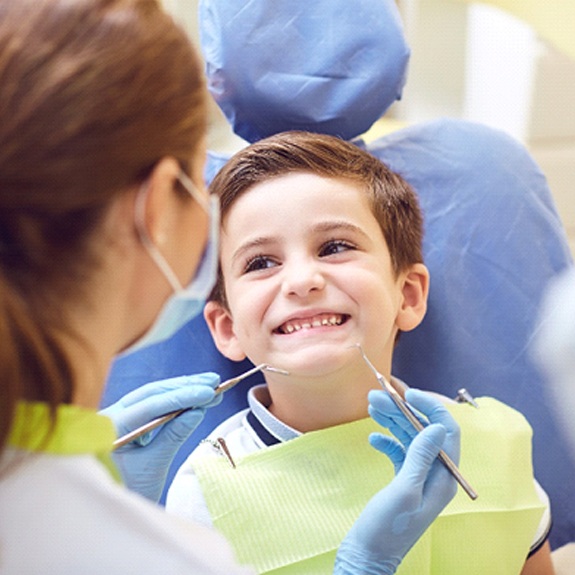 A little boy smiling at his dentist during a regular checkup