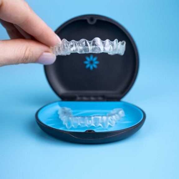 person holding aligners in an Invisalign case 