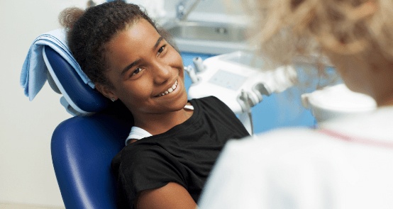 Young girl smiling at dentist during children's dentistry appointment