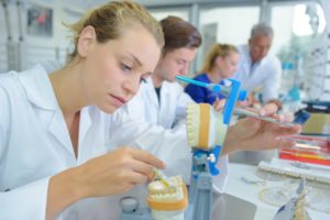 dental technician holding dentures  