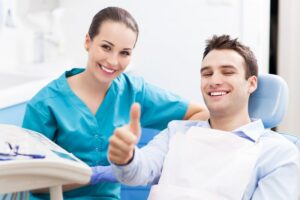 Dentist with patient giving the thumbs-up. 
